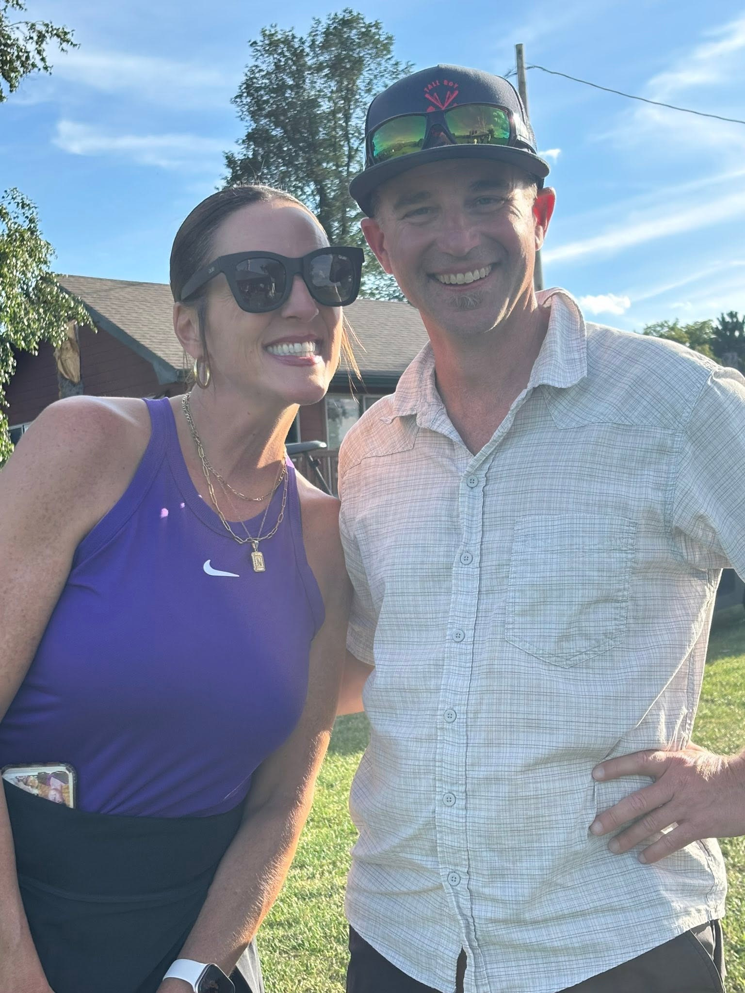 Two tournament participants smiling together beside the golf course.
