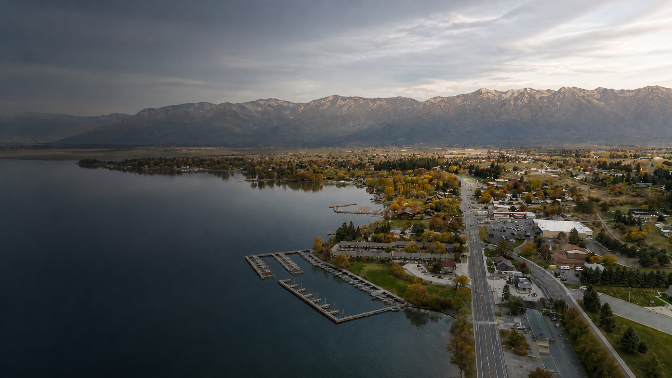 Aerial view of Polson, Flathead Lake, and the Mission Mountains in autumn light.